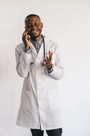 black nurse on a white background speaks on the phoneの写真素材