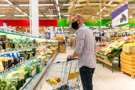 a man wearing a medical mask makes purchases in a supermarketの写真素材