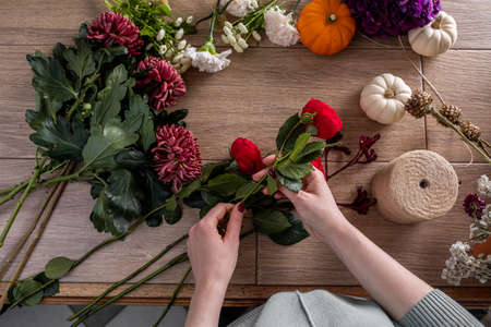 Female florist holding beautiful bouquet at flower shopの写真素材