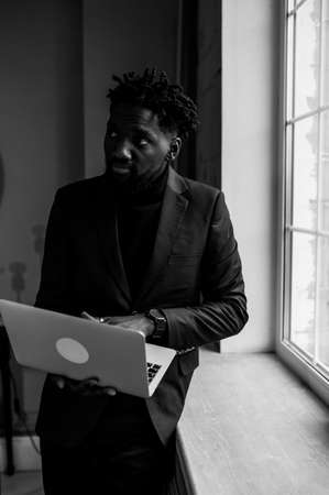 a black man works at a laptop close-up of his face. video conferencesの写真素材