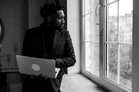 a black man works at a laptop close-up of his face. video conferences