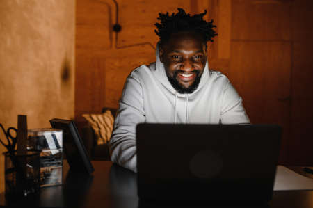 a black man works at a laptop close-up of his face. video conferences