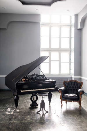 black antique grand piano in the interior with beautiful light from the windowの写真素材