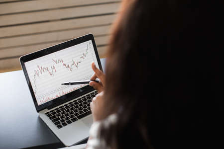 Black Business woman using laptop for analyzing data stock market, forex trading graph, stock...