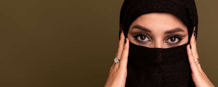 Portrait of beautiful young muslim arabian woman wearing hijab looking at camera, copy space