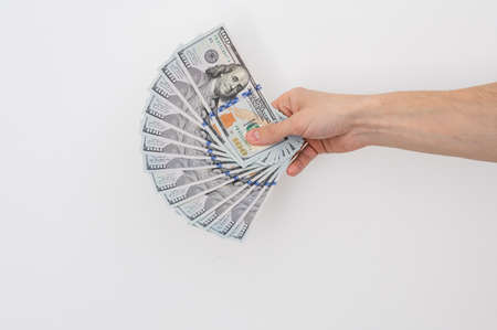 Hands holding a one hundred dollars bill . Hands holding a lot of money . Isolated on white backgroundの写真素材