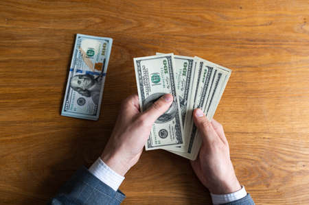 Background with cash money american hundred dollar bills, laptop, phone and docs. Flat lay. Top view