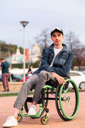 a young man in a wheelchair, walking around the city, enjoying the sunset