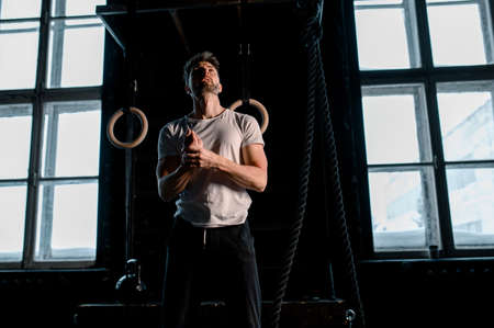 Young Male Athlete With Gymnastic Rings In The Gym. focus on rings
