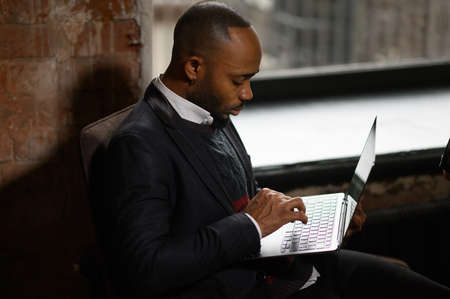a young aspiring African-American investor works at a computer, analyzes the securities market