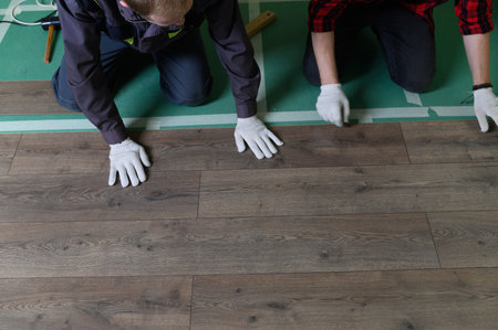 A worker hands knocking on a laminate connecting the panels with a Lock Click.の写真素材