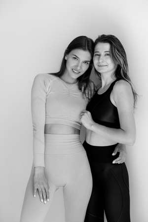 Two sports girls posing isolated on a white background. Fitness model woman in studio with copy spaceの写真素材