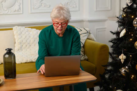 grandma is talking on a video conference with her family. Modern means of communicationの写真素材