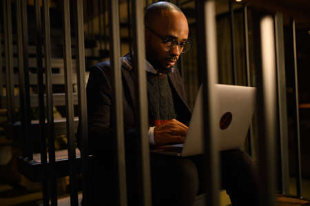 a black man works at a laptop close-up of his face. video conferencesの写真素材