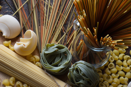 Different raw pasta on the tableの写真素材