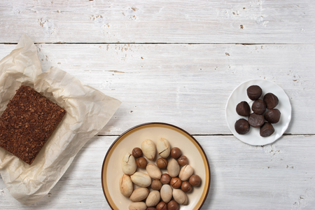 Nuts, truffle candy and chocolate cake on the white wooden table horizontalの写真素材