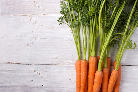 Carrots on the white wooden table horizontalの写真素材