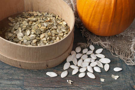 Pumpkin seeds on the rustic wooden tableの写真素材