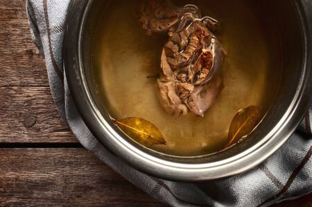 Meat broth from beef in a metal pan on the wooden tableの写真素材