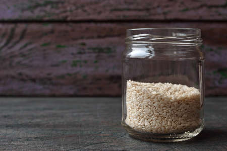 Sesame in the glass jar on the rustic wooden tableの写真素材