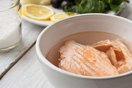 Fish broth from trout in the white ceramic dish on the white tableの写真素材