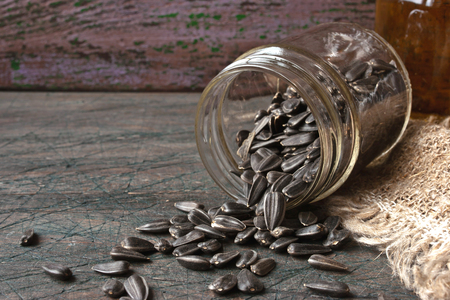 Sunflower seeds in a glass jar on the rustic wooden tableの写真素材
