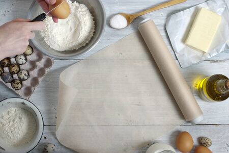Ingredients for the pancakes on the white wooden table around the parchment rollの写真素材