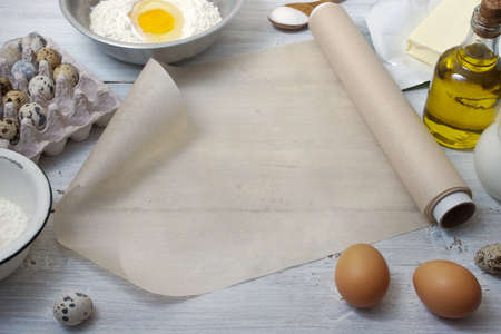 Ingredients for the pancakes on the white wooden table around the parchment rollの写真素材