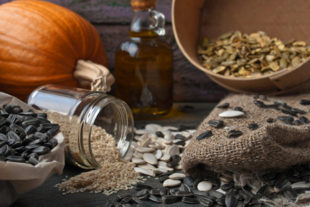Sunflower and pumpkin seeds on the rustic wooden tableの写真素材