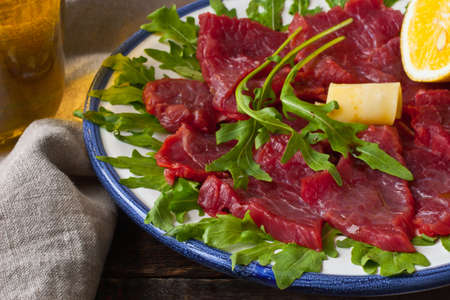 Carpaccio with arugula, tomatoes and cheese on the rustic tableの写真素材