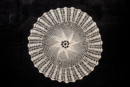 Vintage round lace napkin on the black wooden tableの写真素材