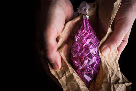 Christmas tree decoration in wrapping paper in the hands horizontalの写真素材
