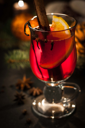 Mulled wine with spices and blurred Christmas decorationsの写真素材