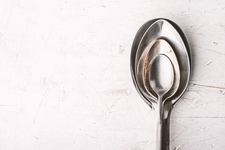 Metal spoons on the white table top viewの写真素材