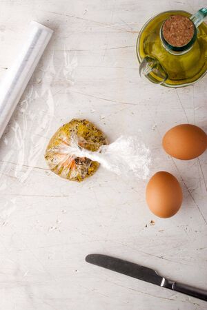 Raw egg  with herbs in the transparent bagの写真素材