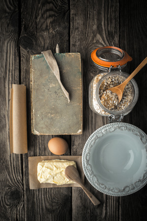Recipe book, plate and ingredients for cookies on a wooden table vertical super still lifeの写真素材