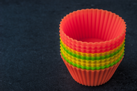 Colorful cupcake molds on the dark tableの写真素材