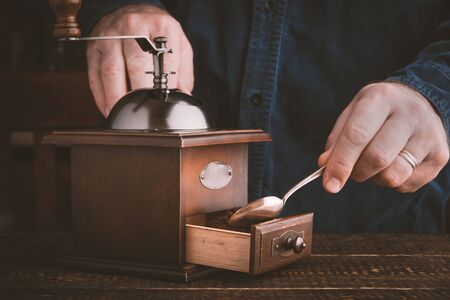 Man making coffee with coffee mill horizontalの写真素材