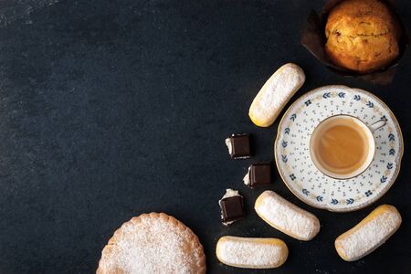 Coffee with different sweets on the dark table top viewの写真素材