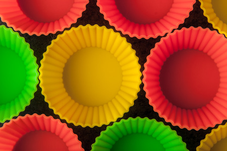 Colorful cupcake molds on the dark table top viewの写真素材