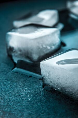 Ice cubes on the dark stone table verticalの写真素材