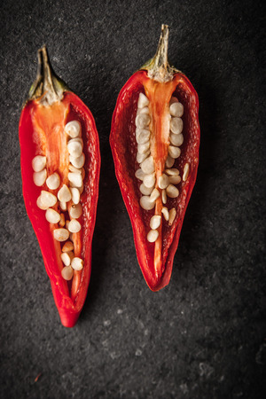 Chili pepper on the dark stone table verticalの写真素材