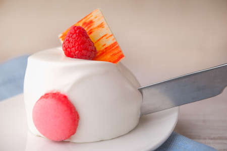 Cutting the white cake with raspberryの写真素材
