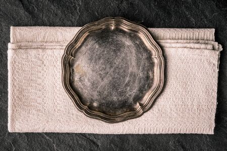 Vintage metal plate on the dark stone table top view