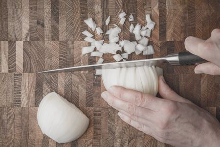 Cutting onion on the wooden boardの写真素材