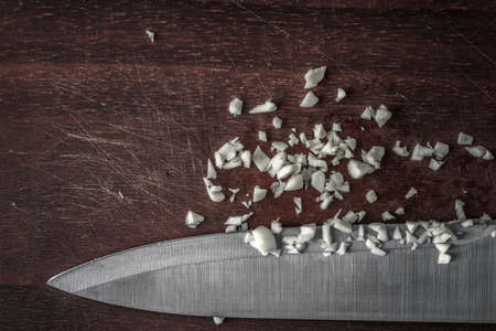 Chopped onion with knife on the wooden board horizontalの写真素材