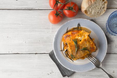 Eating moussaka in the white table with tomatoes and breadの写真素材