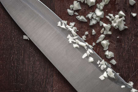 Chopped onion with knife on the wooden board