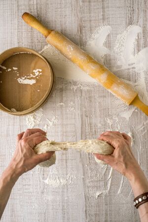 Process of preparing the dough, hands, a rolling pin, sieve flour