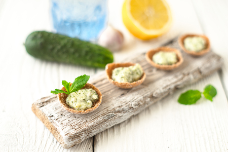 Crisp bread with tzatziki on the white wooden board horizontalの写真素材
